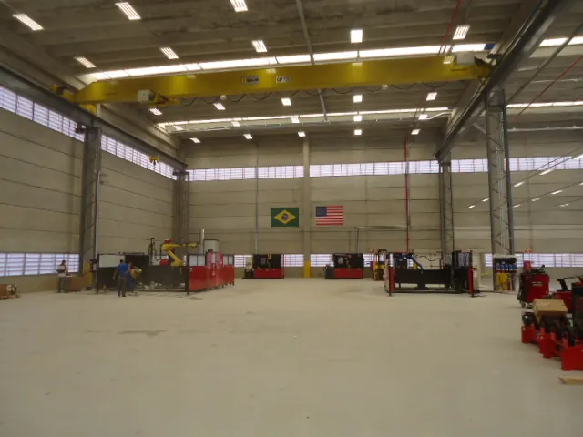 Galpão industrial da Lincoln Electric em Indaiatuba com ponte rolante amarela e bandeiras