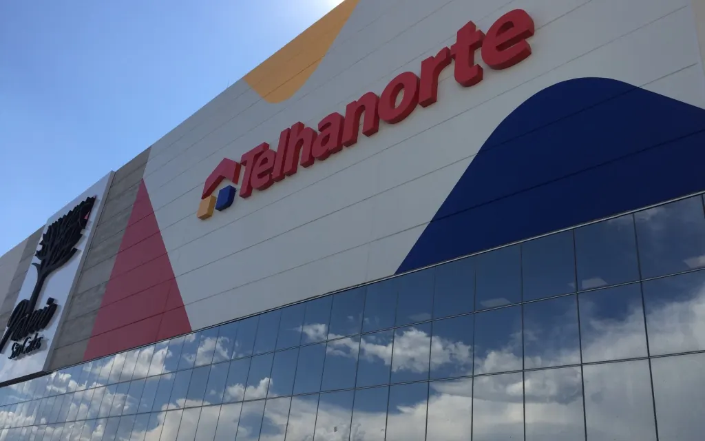 Fachada da loja Telhanorte no Passeio São Carlos, com letreiro e painel vermelho e azul sobre a fachada envidraçada